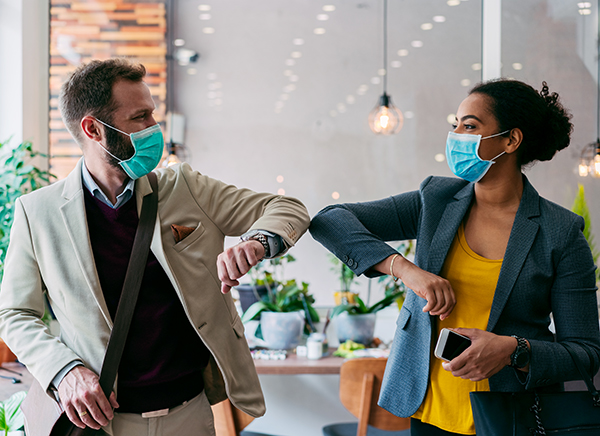 Coworkers with masks elbow rubbing