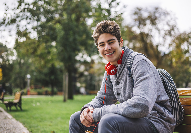 Smiling teenager sitting outside