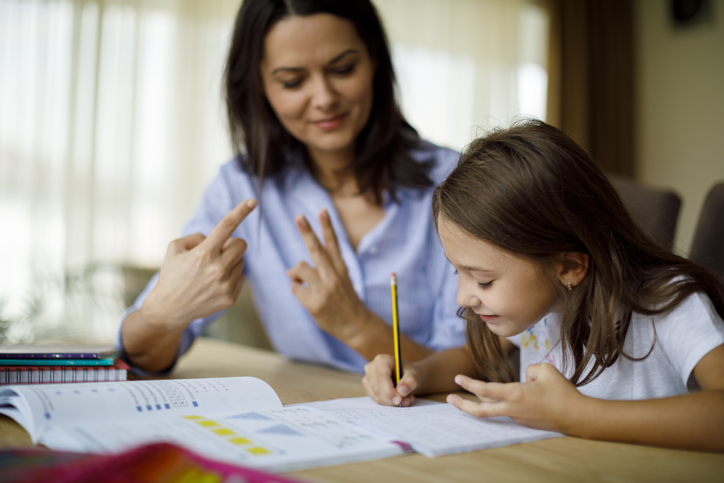 A woman teaching a child (counting together)