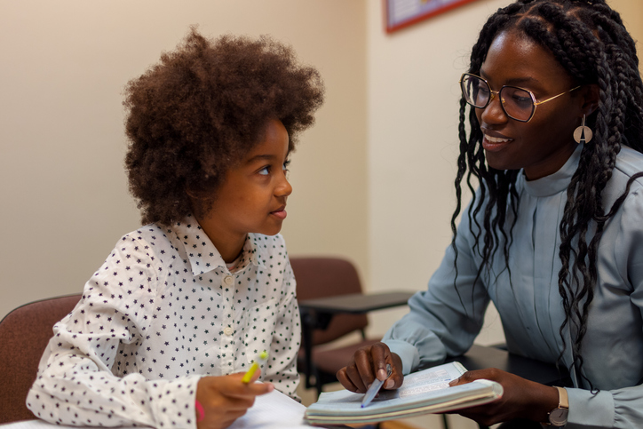 A young female teaching a child