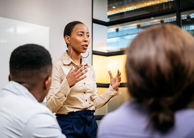 A women presenting in a conference rooom