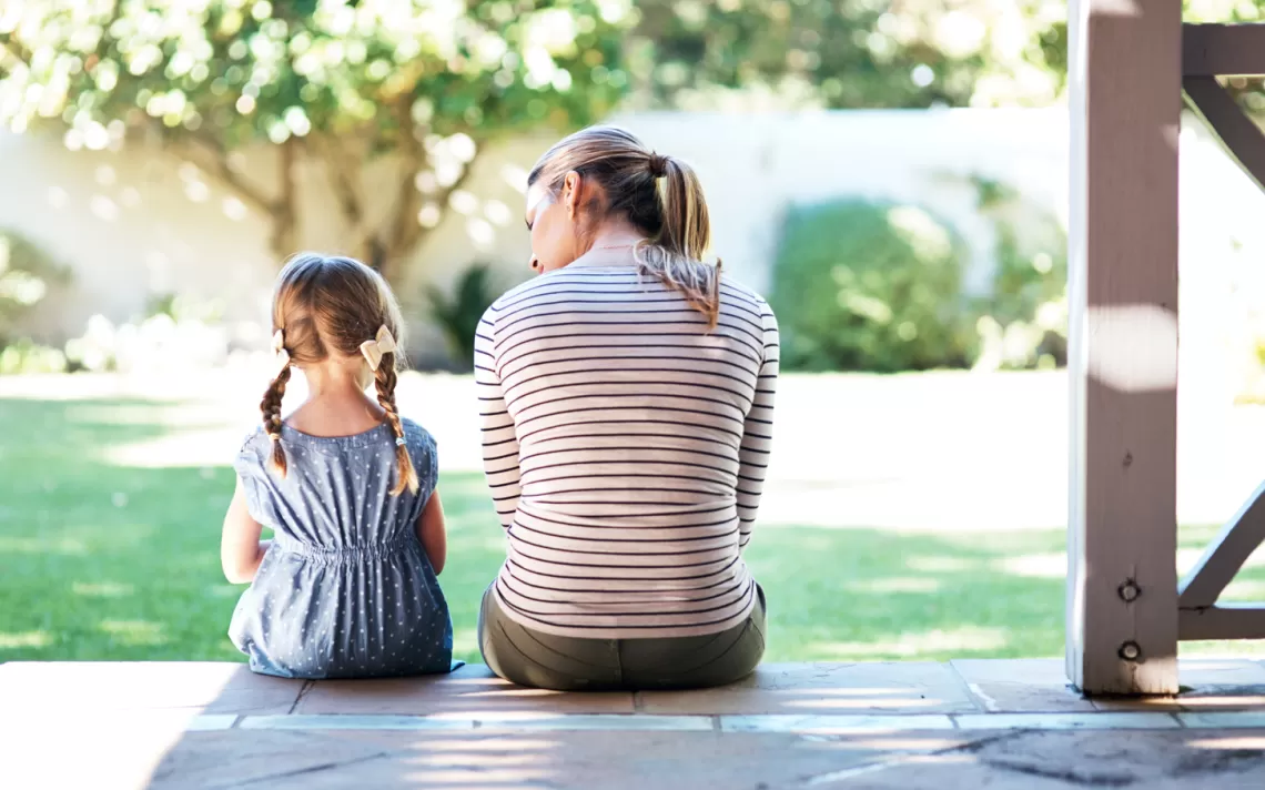 women and child sitting side by side facing away from the viewer