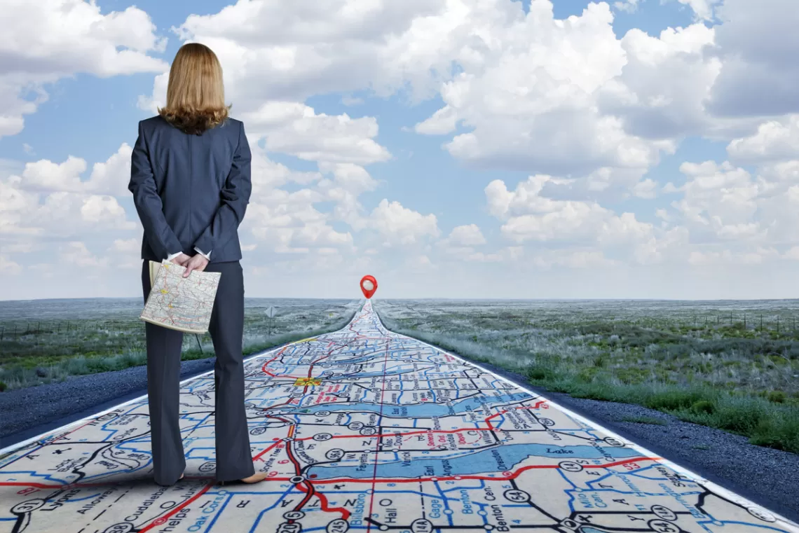 Woman looking down a long road that appears to be a map