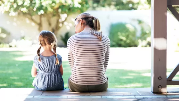 women and child sitting side by side facing away from the viewer