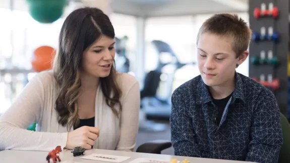 a teacher and a student going over work at a desk