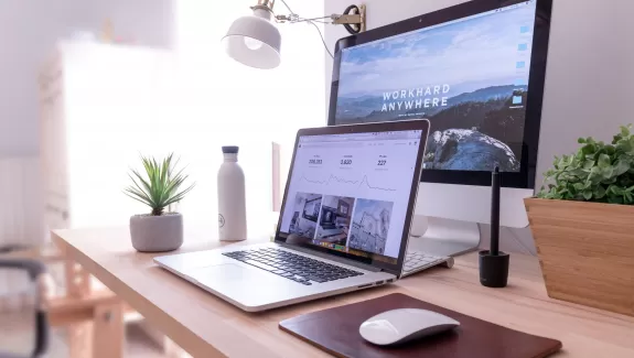 Laptop on a desk with a large screen