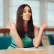 Woman "meditating" at a desk while holding a pencil between her lips and nose